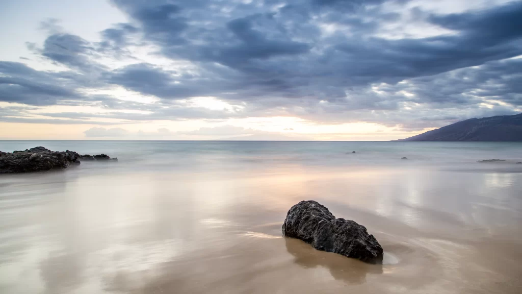 beach sunset clouds calm water rocks