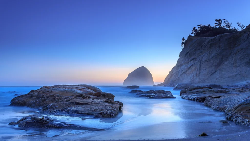 beach sunset ocean rocks cliffs sky
