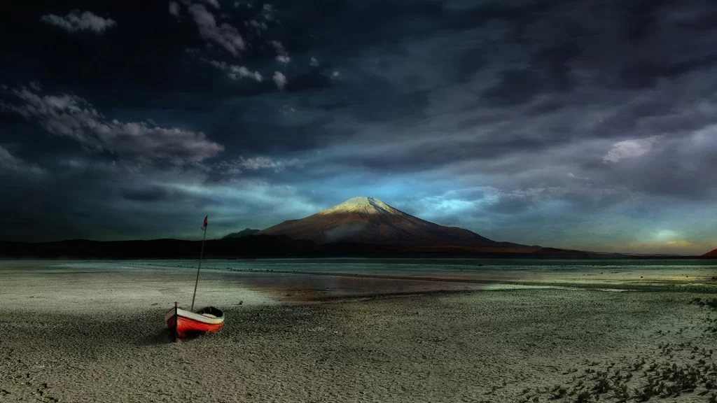 boat mountain beach sky clouds