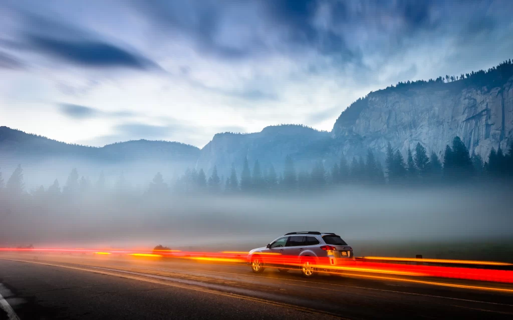 car road mountains fog sky light