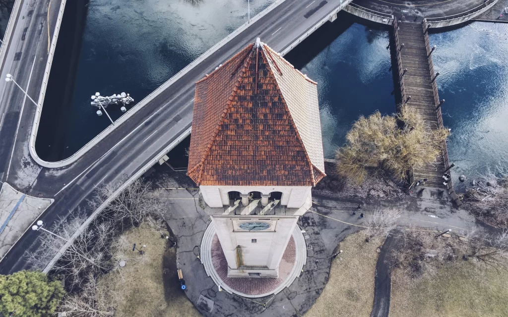 clock tower aerial view bridge water trees road