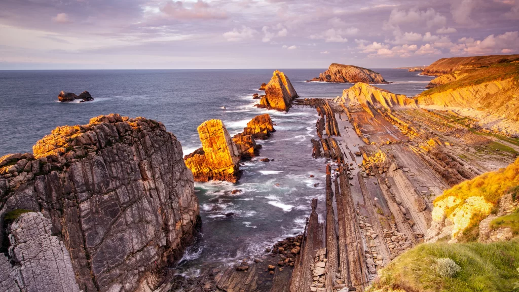 coastal landscape rocky cliffs ocean waves sunset sky