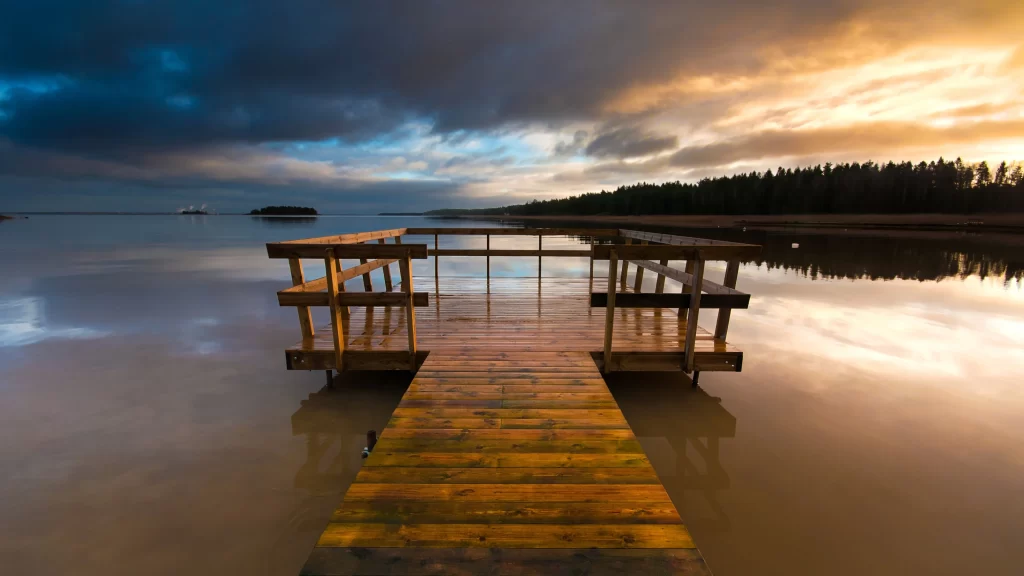 dock water sunset clouds reflection trees
