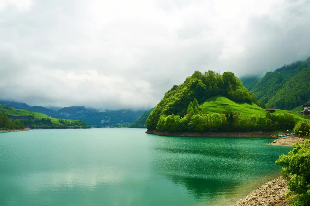 lake green trees mountains clouds water