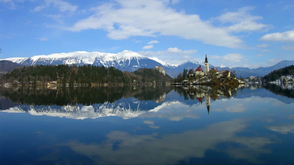lake mountains church reflection snow trees sky clouds