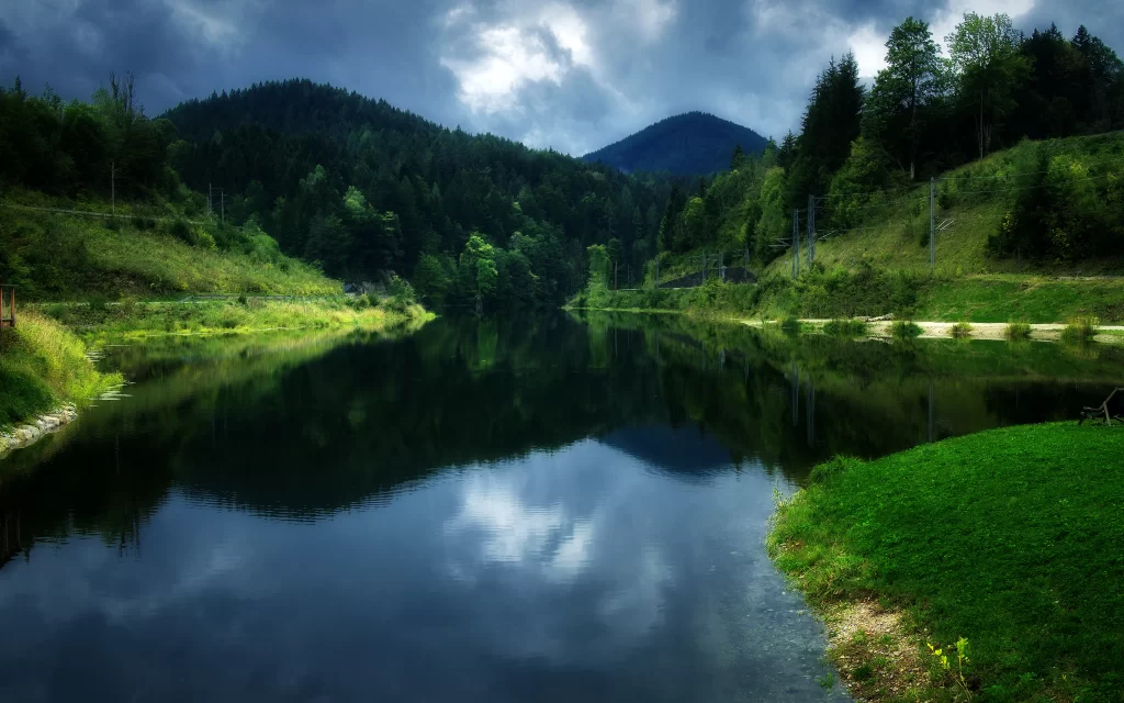 lake mountains trees grass sky clouds