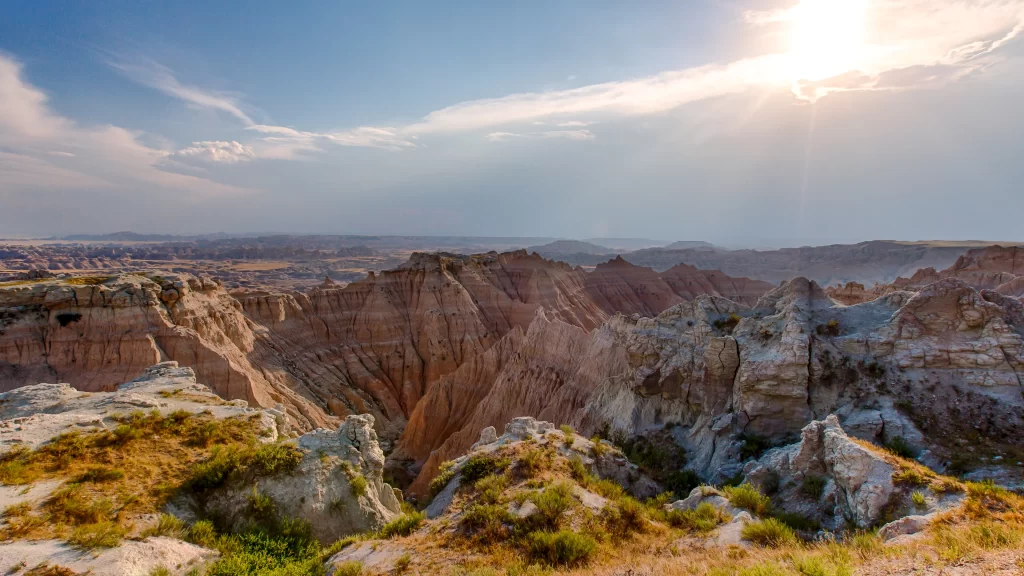 landscape canyon sunlight rock formations grass sky clouds