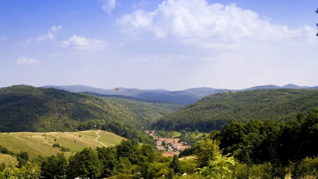landscape hills trees village sky clouds