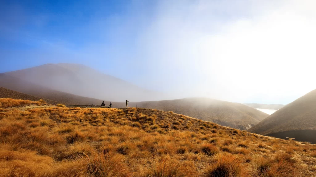 landscape mountains sunlight grass hikers fog