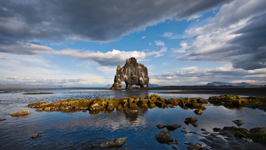landscape rock formation water sky clouds