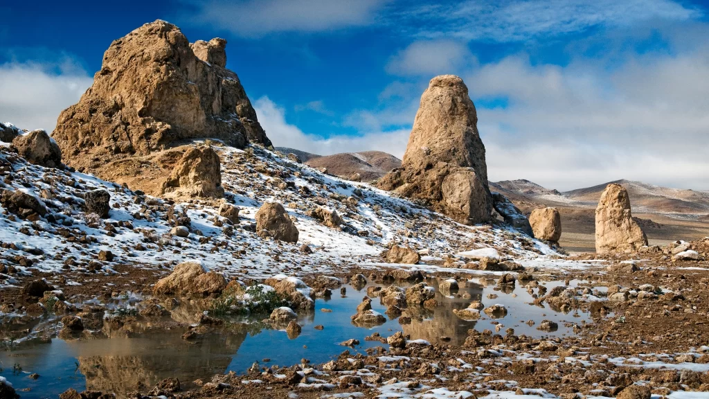 landscape rock formations snow water sky clouds