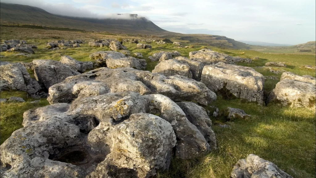landscape rocks grass hills sky clouds