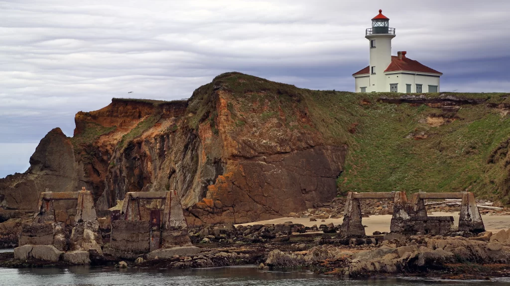 lighthouse cliff ocean ruins clouds landscape