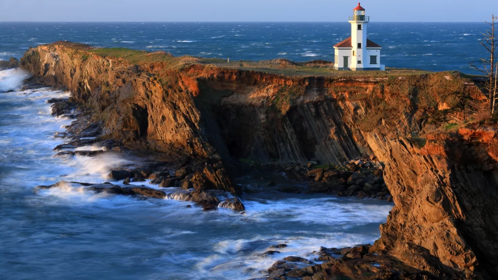 lighthouse cliff ocean waves sunset landscape