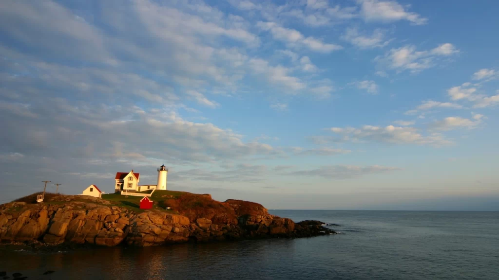 lighthouse rocky coast ocean sunset clouds peaceful