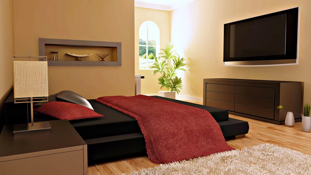 modern bedroom black bed red blanket wooden floor wallmounted TV indoor plants