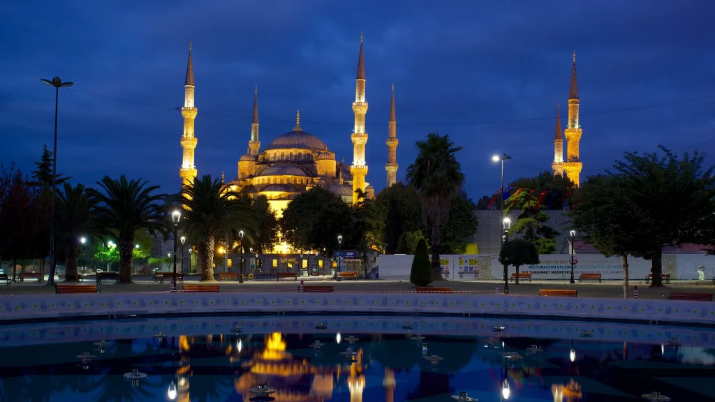 mosque night lights reflection trees water