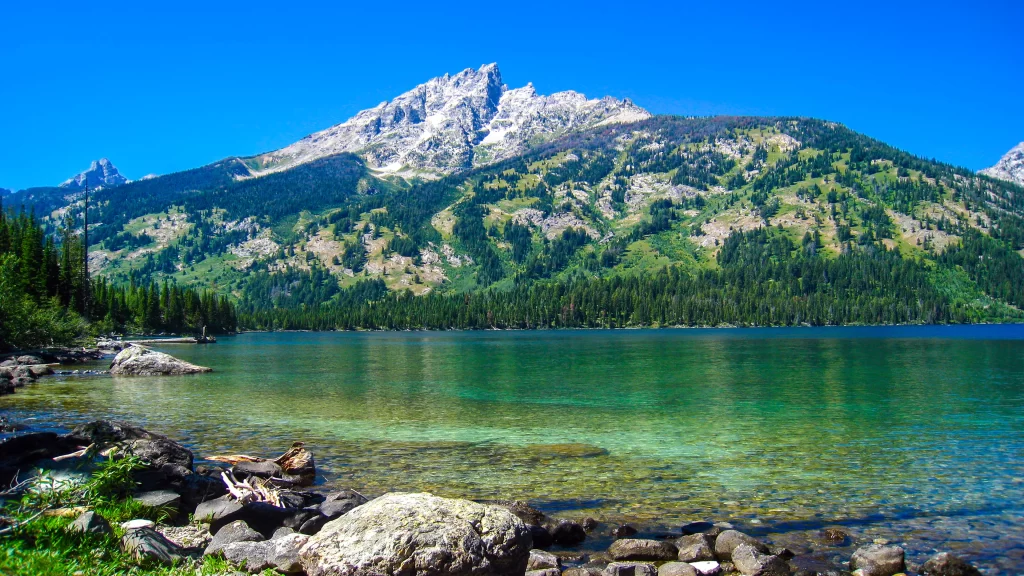 mountain lake clear water greenery blue sky