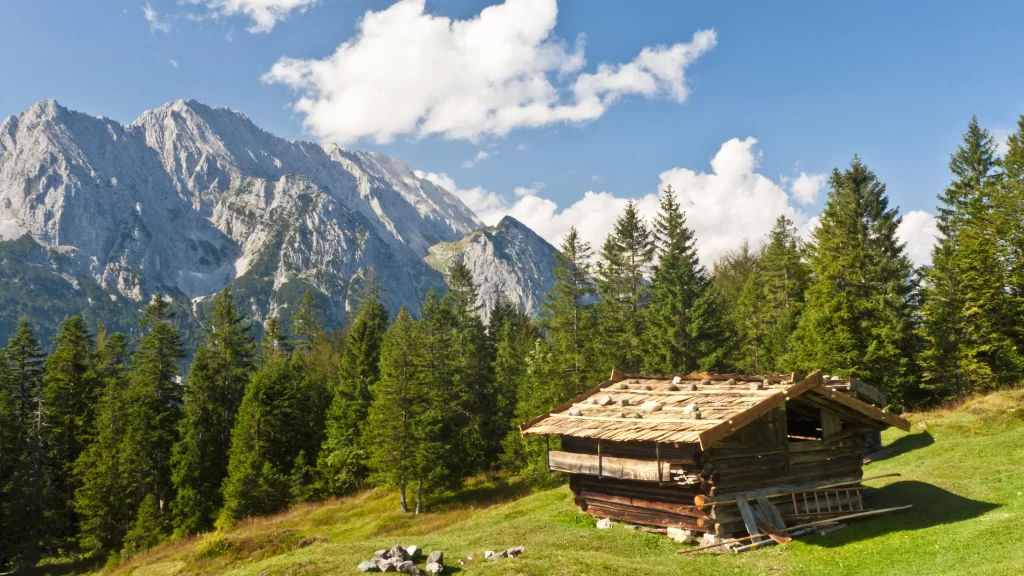 mountains cabin trees grass sky clouds