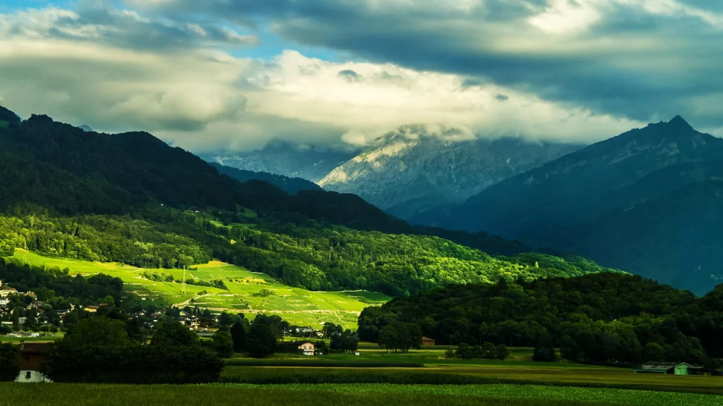 mountains clouds greenery village sunlight landscape