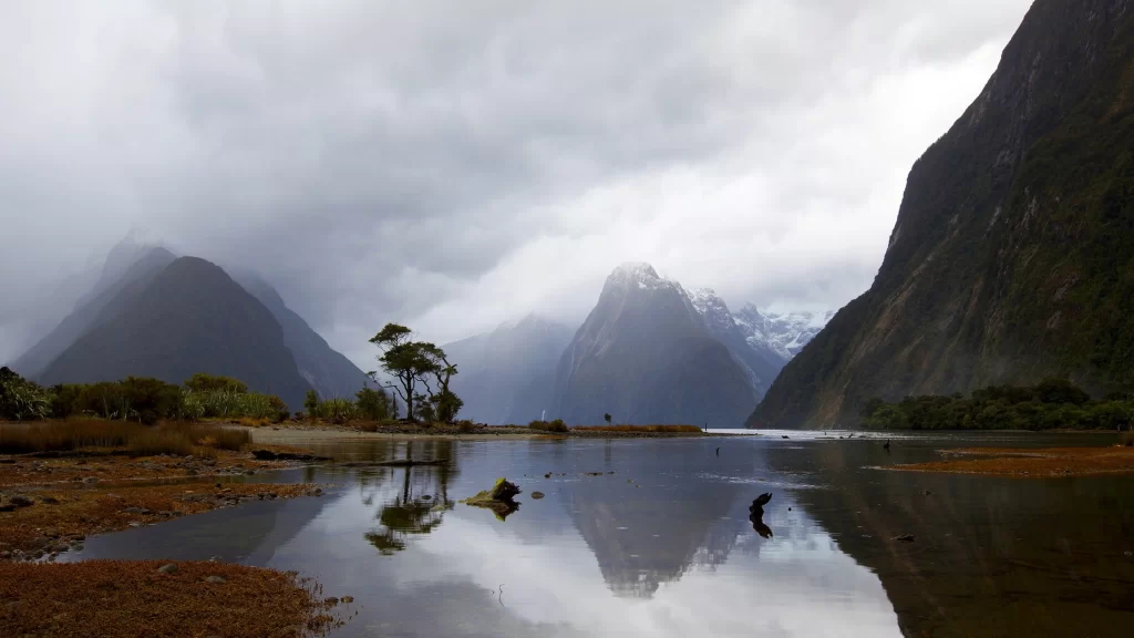 mountains clouds water reflection trees landscape