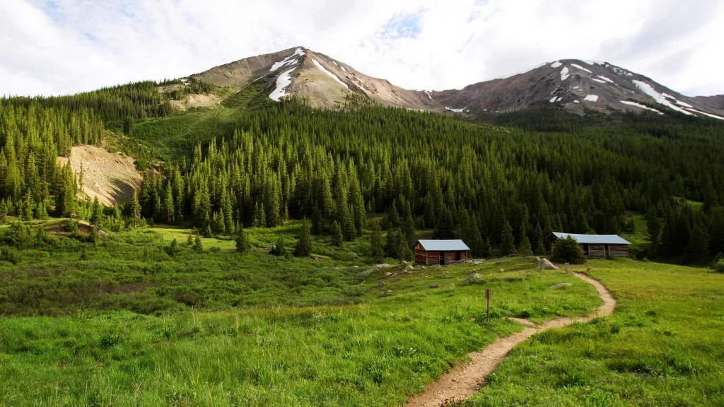 mountains forest path cabins green sky