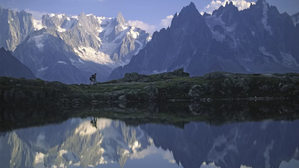 mountains lake reflection hiker snow peaks nature landscape