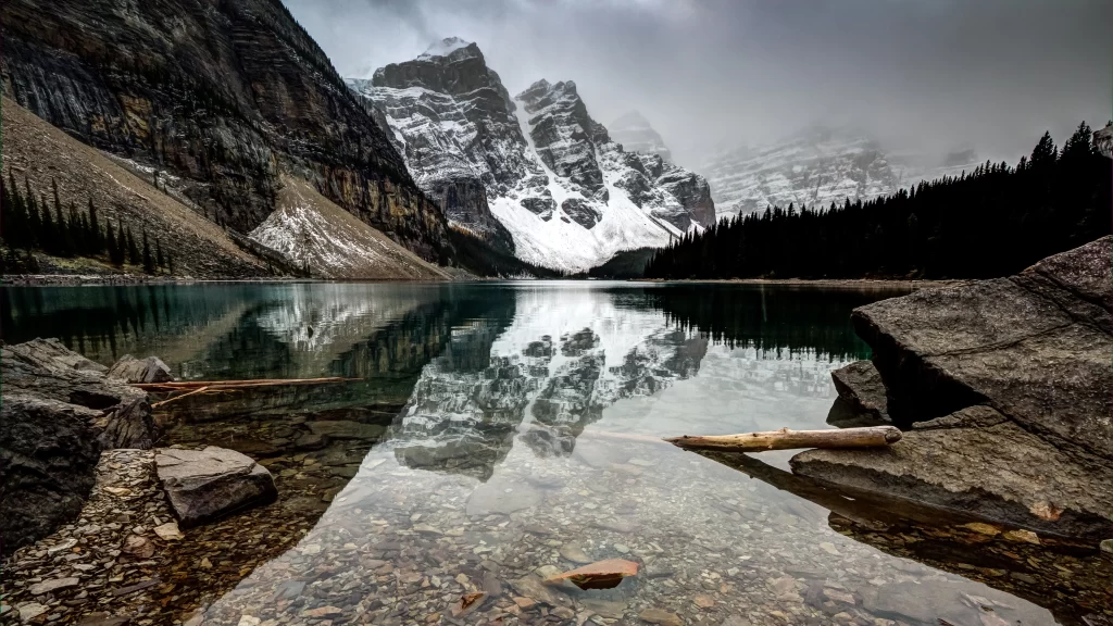 mountains lake reflection rocks snow trees