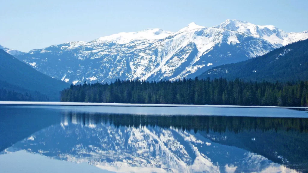mountains lake snow trees reflection