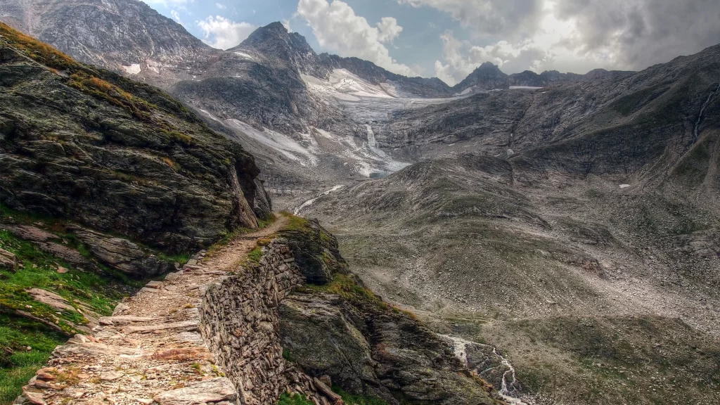 mountains rocky path valley greenery sky