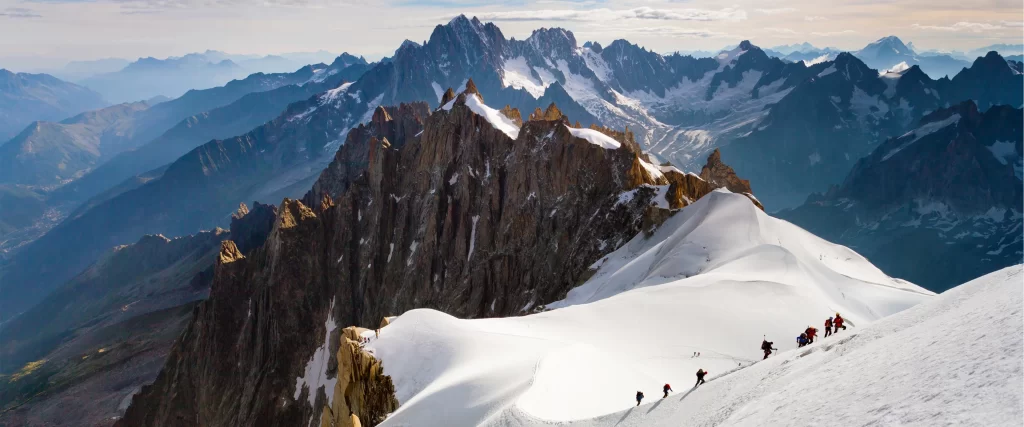 mountains snow climbers rocky peaks sky
