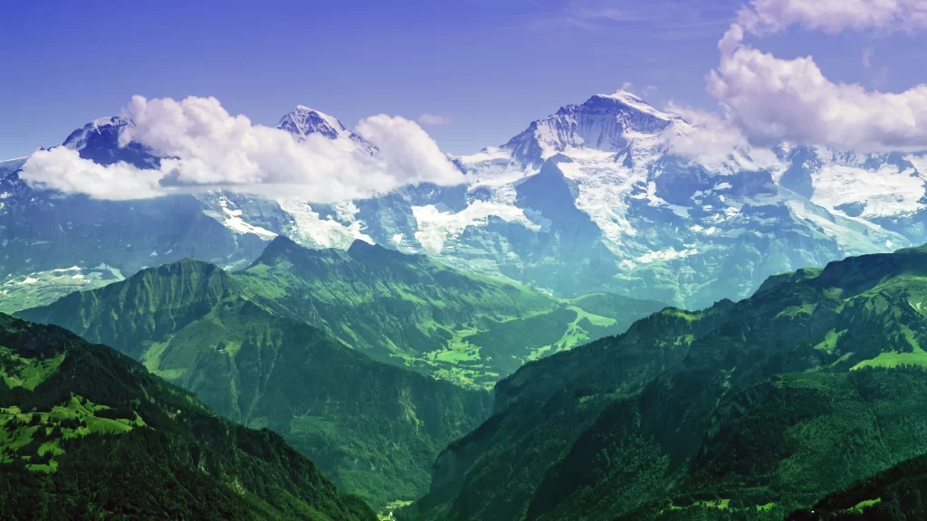 mountains snow clouds green valley