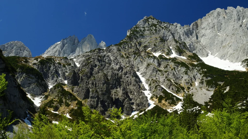 mountains snow greenery clear sky rocky terrain