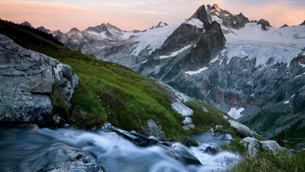 mountains snow stream rocks grass