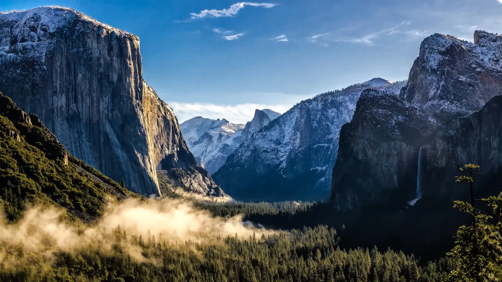 mountains valley mist trees snow sunlight