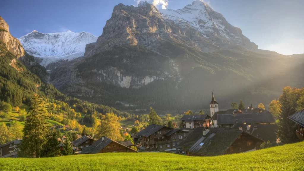 mountains village greenery sunlight buildings nature