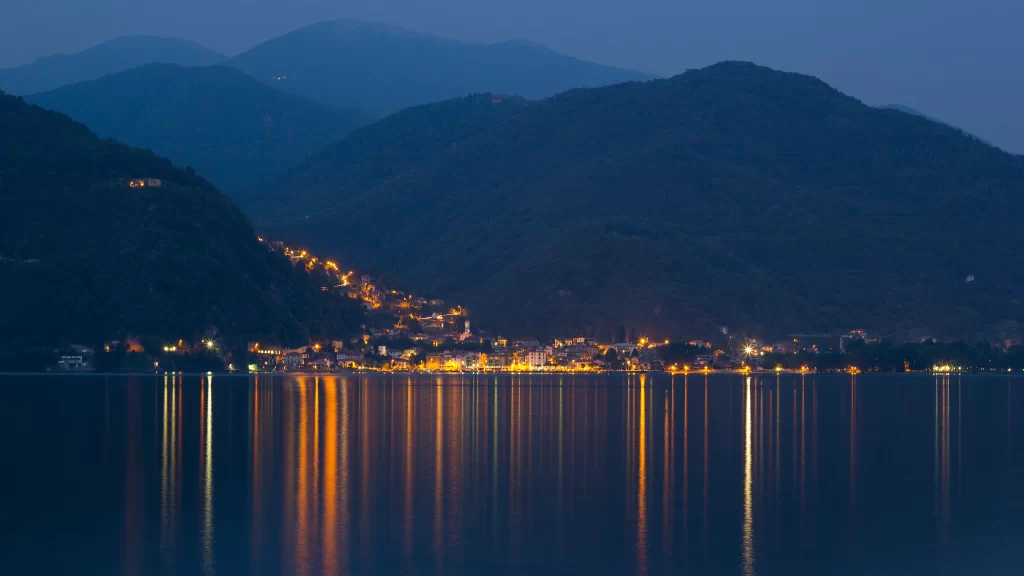 night city lights reflection mountains water