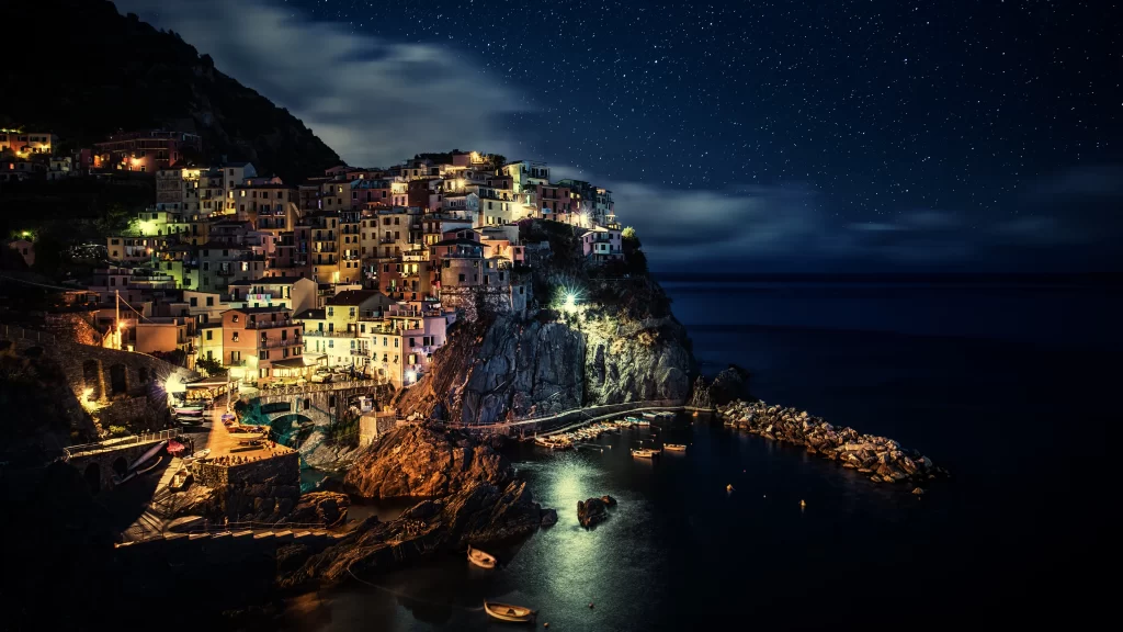 night stars sea village lights cliffs