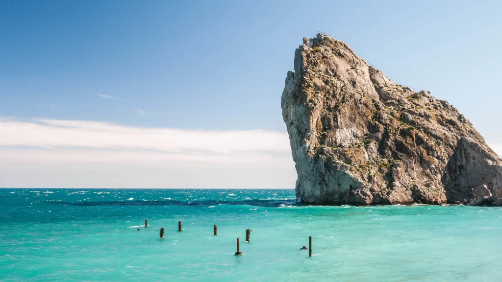 ocean rock clear sky turquoise water