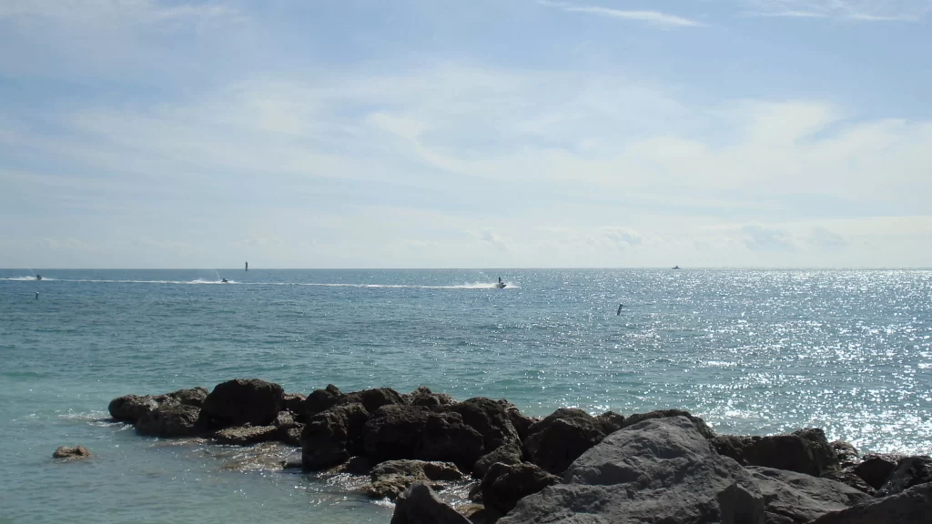ocean rocks water sky clouds sunlight