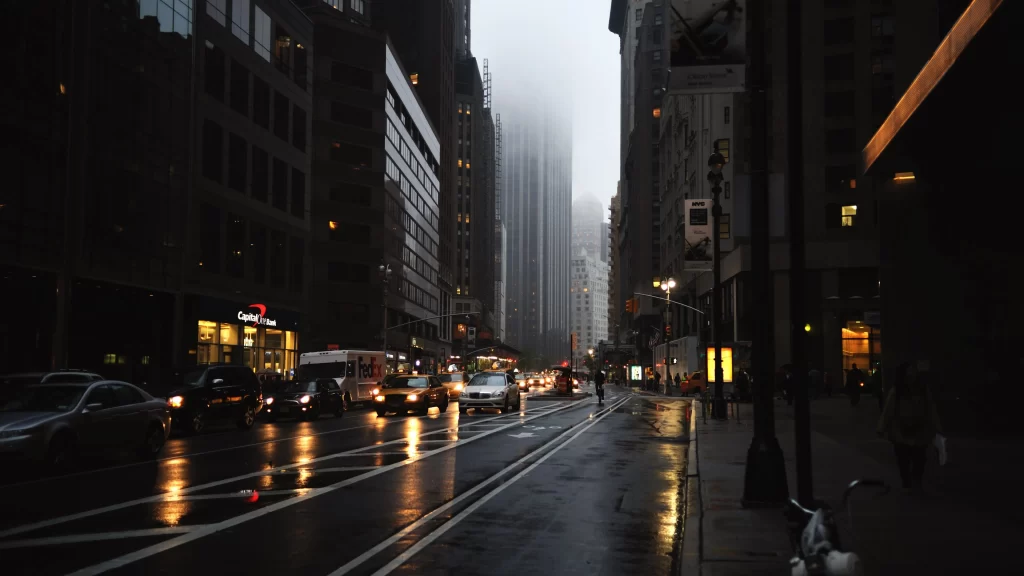 rainy city street cars buildings