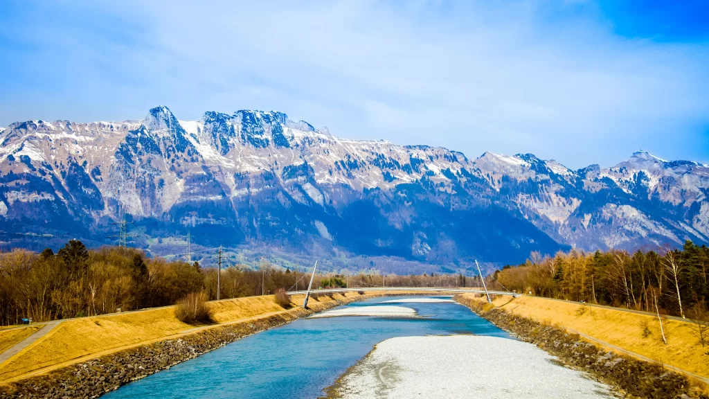 river mountains snow trees bridge sky