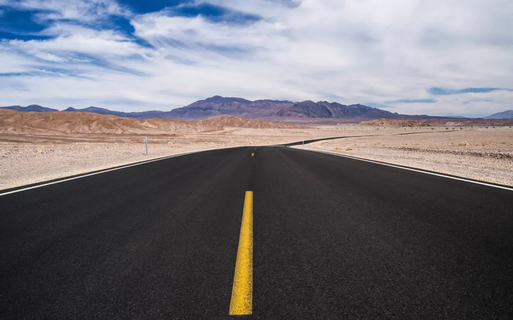 road desert mountains sky clouds horizon
