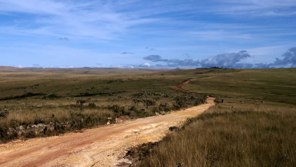 road grassland sky clouds dirt landscape
