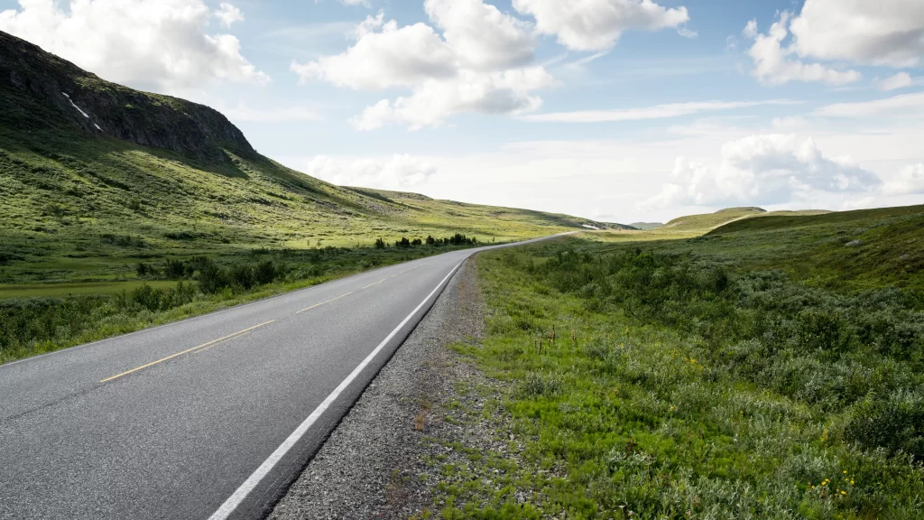 road landscape nature green sky clouds