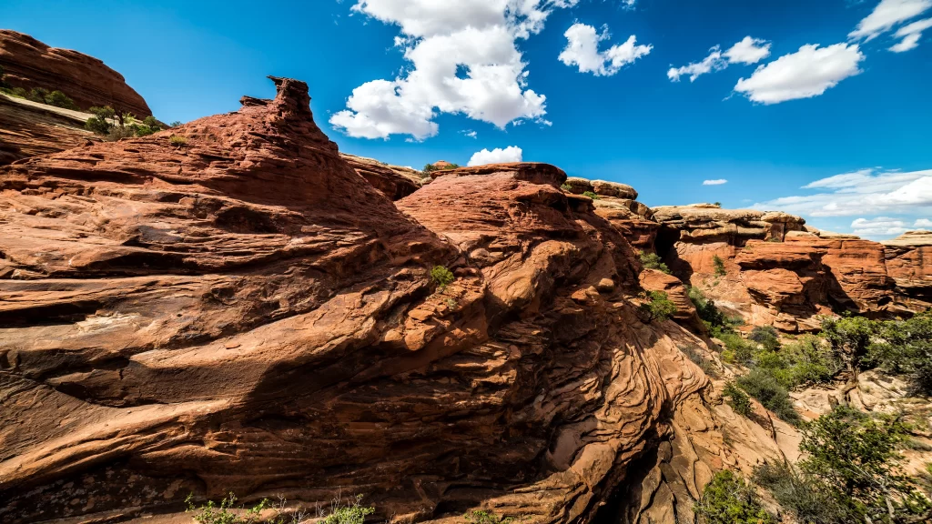 rock formations desert blue sky clouds vegetation erosion