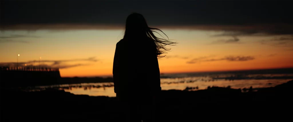 silhouette sunset beach woman hair sky