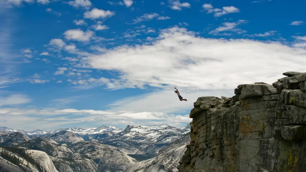 sky clouds mountains cliff person jump