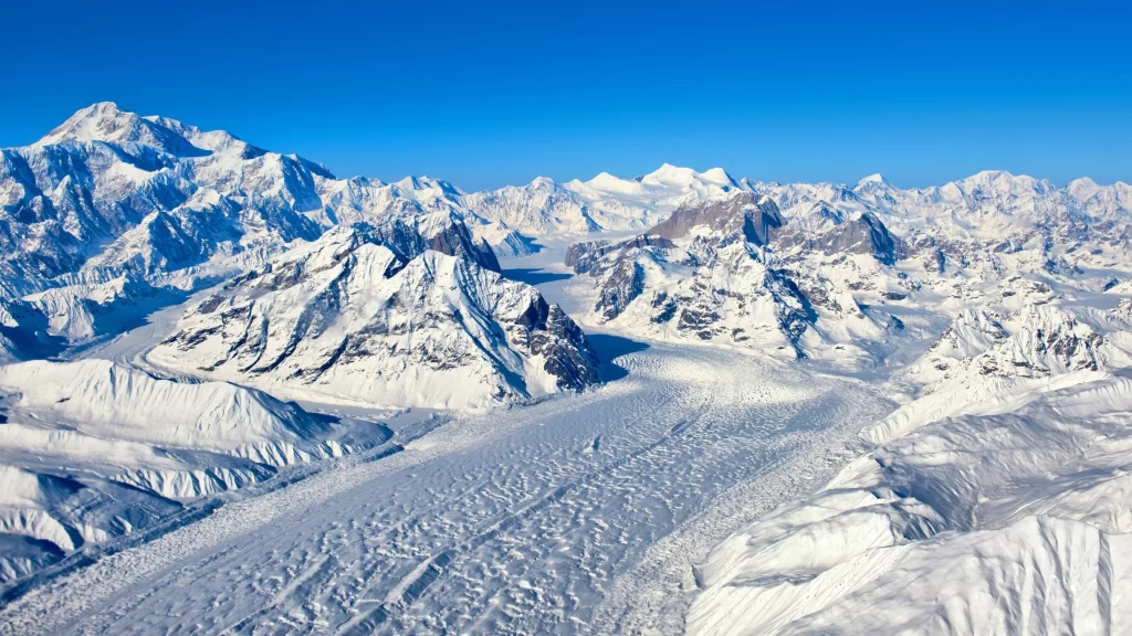 snow mountain range clear blue sky white peaks glacier rugged terrain serene lan