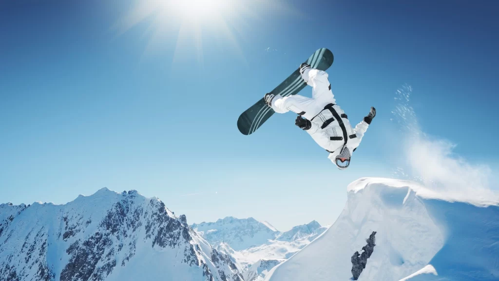 snowboarder snow mountains sky sun jump winter sport